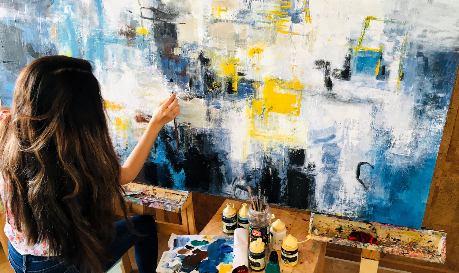 Artist working on an abstract painting, illustrating the attentive and handmade process.